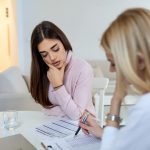 Medical billing professional reviewing insurance documents and Explanation of Benefits statements in office setting