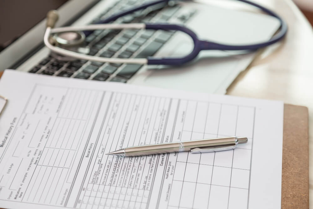 Medical professional reviewing insurance documents to obtain prior authorization before performing a procedure.