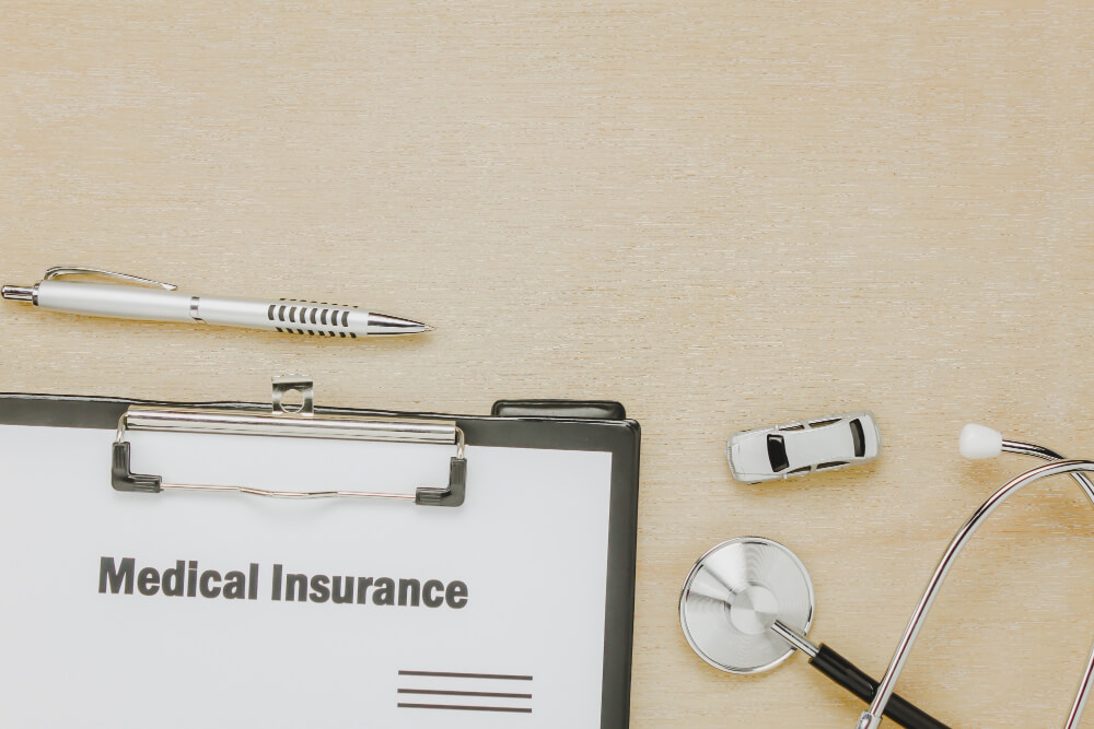 pen, sthetoscope, medical bills, and insurance documents showing coinsurance cost calculation.